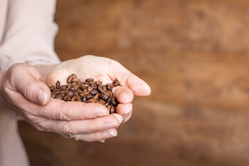 coffee beans large in hand on a light background