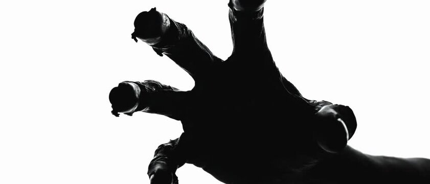 Silhouette of a zombie hand on white background in slow motion