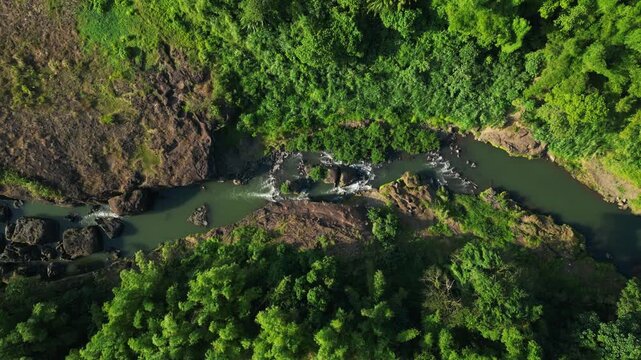 Daylight view of Bucal Tulay river with powerful flowing water carving dramatic rock formations beneath the bridge in rural Maragondon Cavite Philippines.