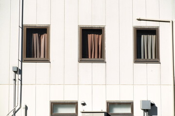 Fototapeta premium 白い外壁に並ぶ3つの窓とミニマルな建築美