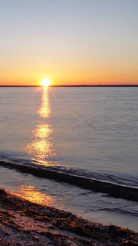 Ruhiger Sonnenuntergang &uuml;ber dem Meer mit goldenem Licht auf sanften Wellen, entspannende Naturstimmung, minimalistische Landschaft im Hochformat, viel Freiraum f&uuml;r Text