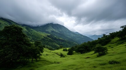 Fototapeta premium A breathtaking panoramic view of lush green rolling hills and dramatic cloudy mountains under an overcast sky