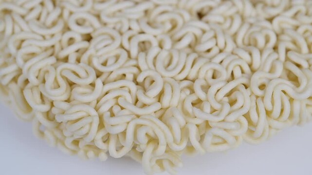 Highresolution image showcasing intertwined noodle strands pattern. Close examination of pale beige instant noodles with intricate curl formations and compact shape