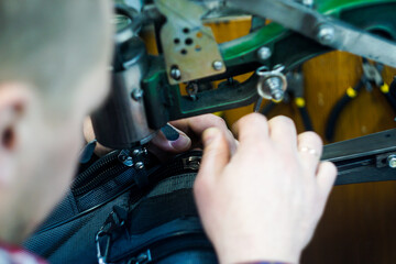 Obraz premium A man in a workshop uses an old sewing machine to make a leather product