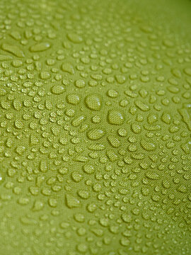 Water drops on green waterproof fabric.