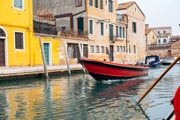 Boat moves through a canal in a historic city during a quiet day of exploration