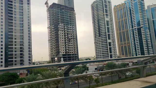 A ride on public transport. View from a ground-level metro window. View from a public transport window. Skyscrapers. Speed. City Skyline. Train view.