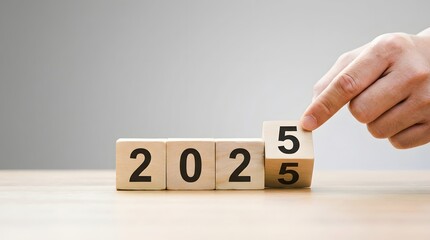 Naklejka premium Hand adjusting wooden number blocks to 2025 isolated on transparent background