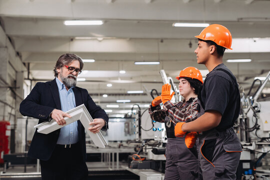 Manager educating young workers about window manufacturing