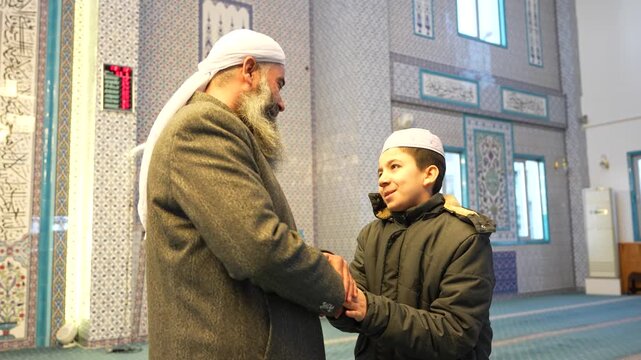 A Muslim sheikh hugging children in a mosque and congratulating them on the occasion of Eid al-Fitr. Islamic holidays. Muslims celebrating Eid al-Fitr after the end of the month of Ramadan.