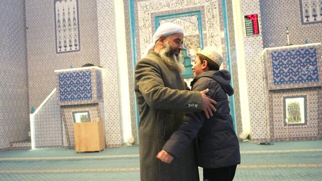 A Muslim sheikh hugging children in a mosque and congratulating them on the occasion of Eid al-Fitr. Islamic holidays. Muslims celebrating Eid al-Fitr after the end of the month of Ramadan.