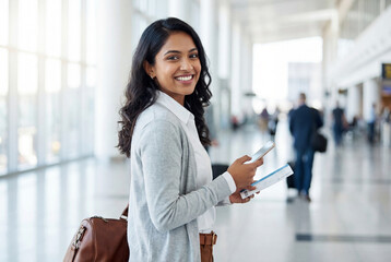 young indian woman holding ticket and smartphone standing at airport