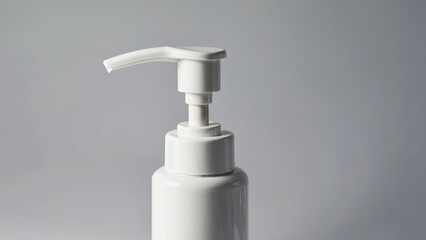 Obraz premium White plastic pump bottle with angled dispenser on neutral gray background