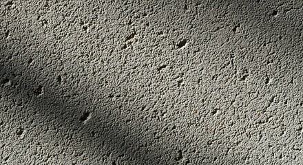 Close-up view of a rough, textured concrete surface with small pits and uneven grain pattern