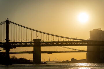 Fototapeta premium Brooklyn et Manhattan Bridge au coucher du soleil avec la statue de la liberté derrière