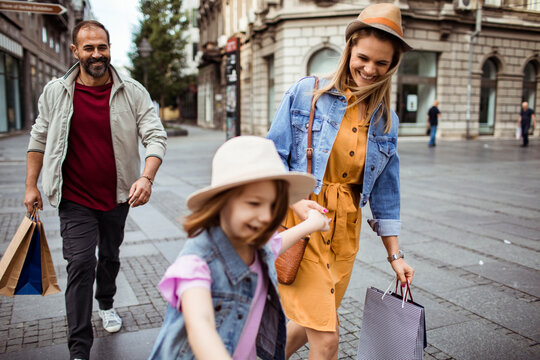 Smiling family shopping together on city street