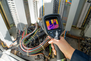 Thermal camera checks predictive maintenance inside an electrical control cabinet, detecting heat anomalies in cable connections to support safety, reliability, and diagnosis. © JD Studio