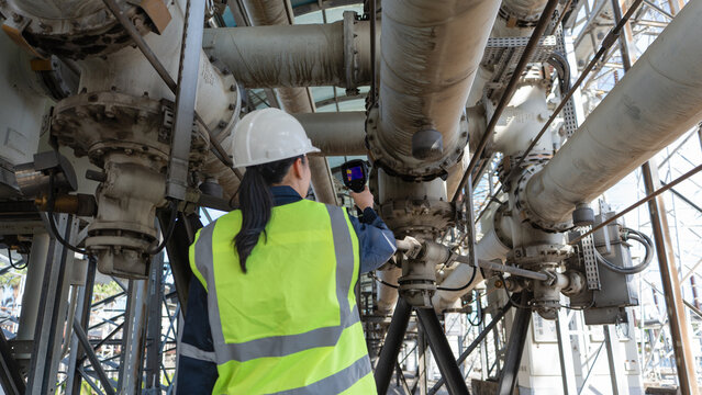 Engineer performs industrial monitoring with a thermal camera on high voltage gas insulated equipment, supporting heat inspection, safety, reliability, maintenance, and diagnostics.