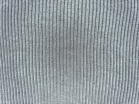 vertical ribbed knit fabric texture closeup in soft gray tones with subtle central shadow