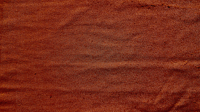 terracotta woven denim fabric macro texture closeup with intricate threads and natural creases in rustic earthy tones