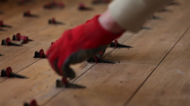 Man fixing Tile Leveling System Components. Man tiling a floor. 4K