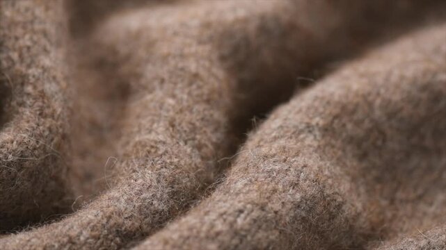 Wool knitted background. Real natural beige color wool mohair clothes texture closeup. Craft Cashmere Soft and fluffy merino wool macro shot. Woolen fabric rotating backdrop. 