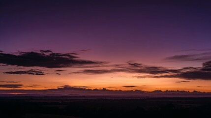 Breathtaking sunset sky with dramatic transition from deep violet and purple to warm orange and yellow hues, soft scattered clouds forming natural texture, peaceful evening atmosphere in nature