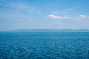 Blue ocean seascape with distant island horizon