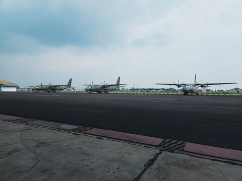 Three CN235 Military Transport Aircraft Parked in Formation on Airbase Runway Under Cloudy Sky