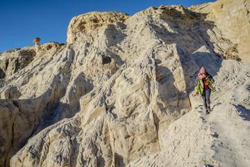 A person is walking up a rocky hill
