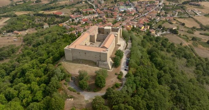 Aerial view of Lagopesole Castle, located in Basilicata, Italy. It is a medieval fort dating back to the time of Frederick II. A stone fortress perched on a lush green hilltop, overlooking the village