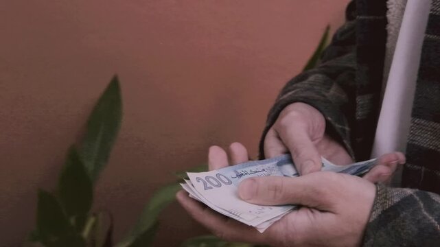 closeup male hands hold Moroccan dirham money, count paper dirham banknotes, concept cash payments, monetary savings, save for vacation, exchange and cashing currency