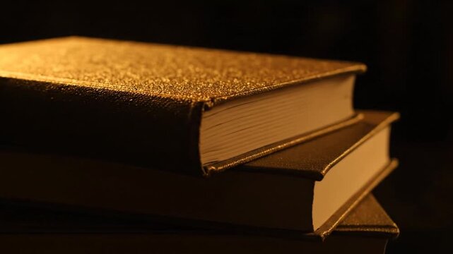 Stacked gold books dark.