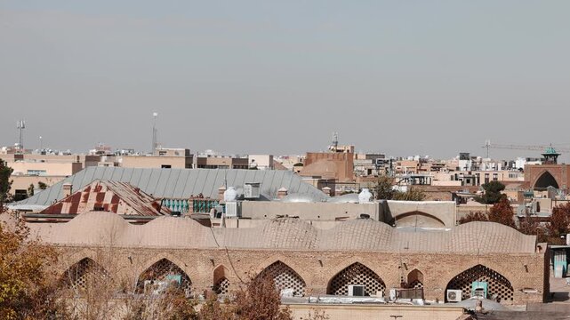 Panoramic aerial view of the Old City of Isfahan, Iran, with historic mosques and dense rooftops visible across the urban landscape as a sandstorm approaches the city. Dramatic desert dust storm