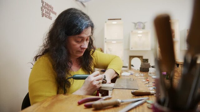 Woman jeweler polishing a ring with a rotary tool