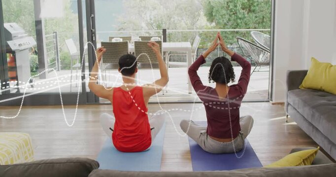 Two adults following health audio cue doing synced arm raises while waveforms partly obscuring arms