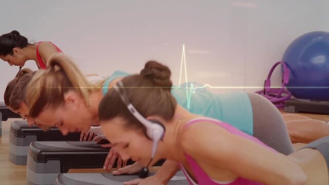 Vertical video: Leading pink-clad coach mic cueing tempo for pushups on steps in studio, copy space
