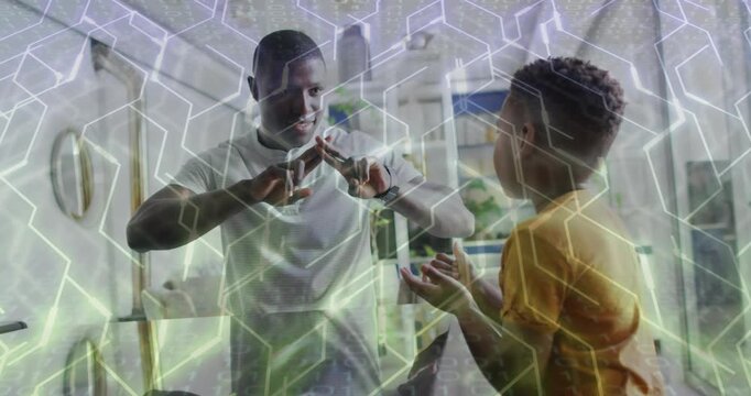 Dad moving hands and teaching son crossing fingers in kitchen for education, hex overlay animating