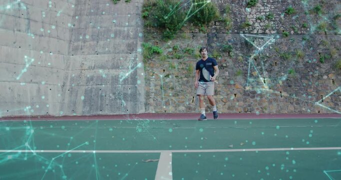 Male tennis player walking to center, starting racket swings, warming up with teal overlay onscreen