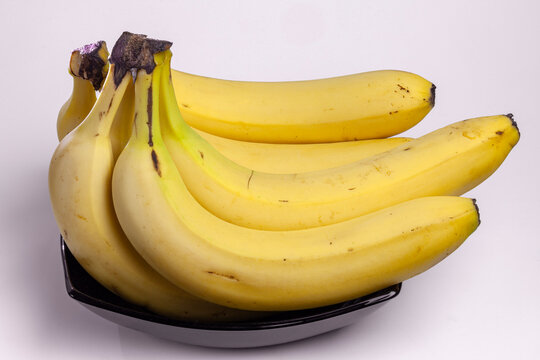 Bunch of ripe yellow bananas in black bowl