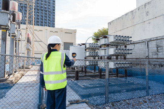 Technician performs substation maintenance with an infrared camera on capacitor bank equipment, supporting preventive maintenance, safety monitoring, fault detection, and reliability.