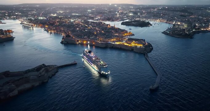 Malta, Valletta - 11.10.2025: Cruise luminous ship leaves the port of Valletta at night. Malta 