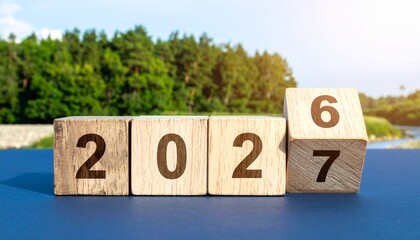 Wooden Blocks on a Table Flipping from 2026 to 2027 with a Scenic Forest and River Background
