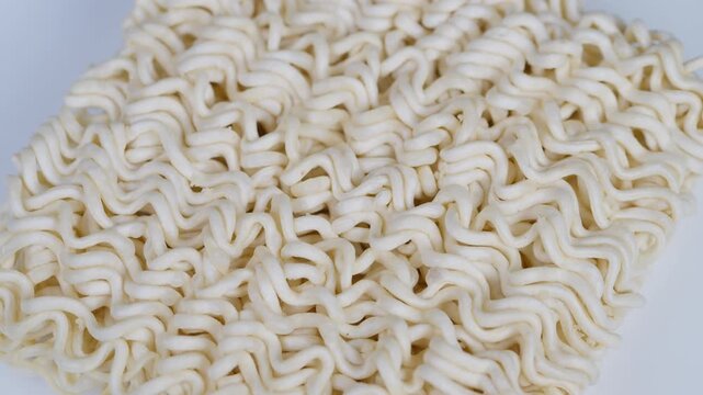 Closeup of curly dried noodles. Macro shot highlighting noodle texture and pattern. Highresolution image capturing intricate surface and wavy pattern of raw ramen strands