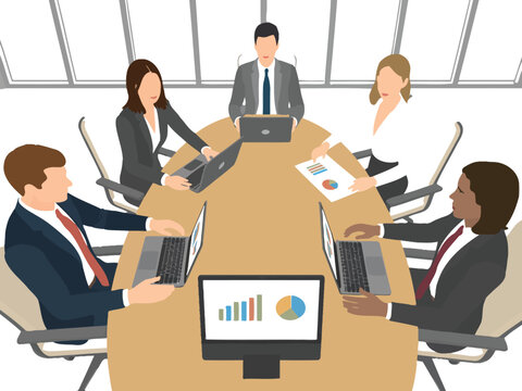 Diverse team collaborates around a conference table with laptops and charts, planning future strategy.