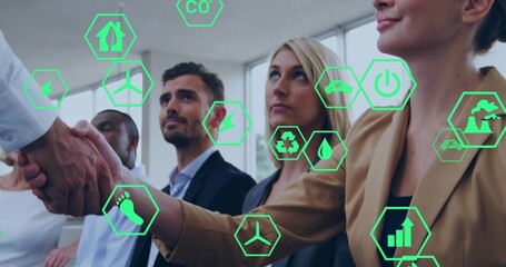 Shaking hands, seated business team in suits in boardroom with green hex icons for sustainability