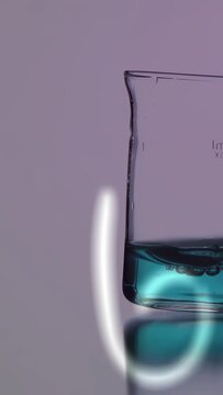 Vertical video: Neon stroke starting equations sliding, beaker sitting with teal liquid for STEM
