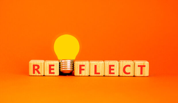 Reflect word symbol. Concept word Reflect on beautiful wooden blocks. Beautiful orange background. Beautiful yellow light bulb. Business psychological reflect word concept. Copy space.