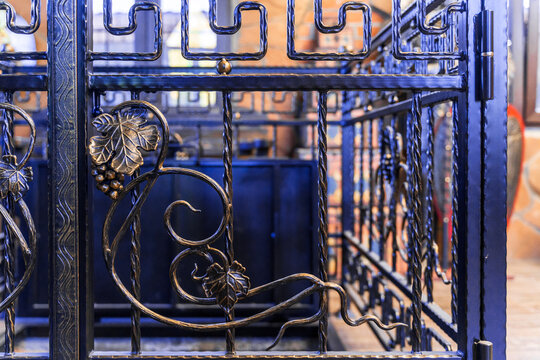 Ancient forged lattice-fence with grape leaves and berries