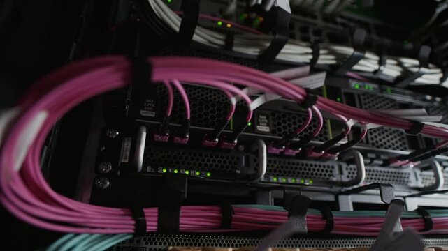 Macro close up shot of fiber optic cables connected to servers in data center rack, high speed network infrastructure and internet backbone technology concept
